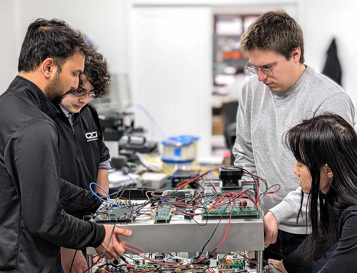 Engineering team working on electronic circuit prototypes at Optogration Inc.